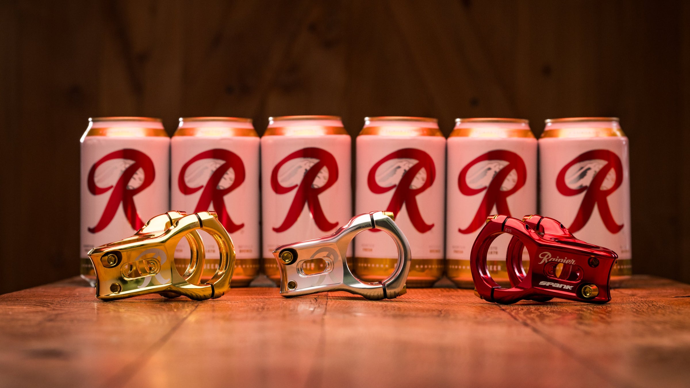 Row of cans with 'RRR' branding on a wooden surface with beer bottle openers.